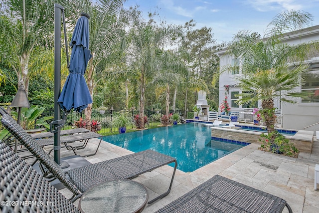 view of swimming pool featuring an in ground hot tub, an outdoor fireplace, and a patio area