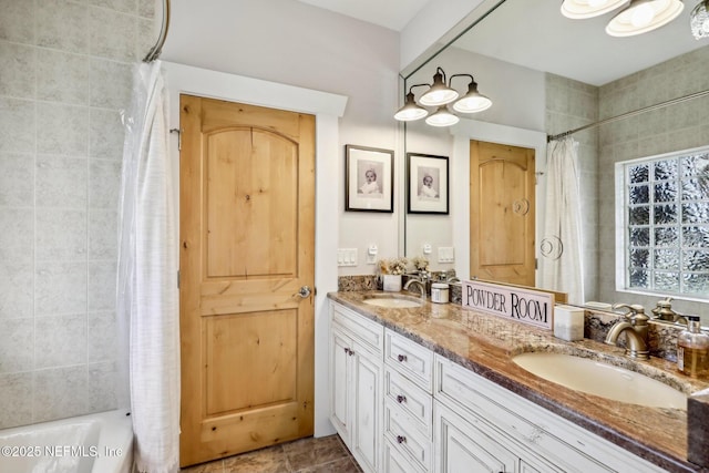 bathroom with double vanity, a sink, and shower / bath combo with shower curtain