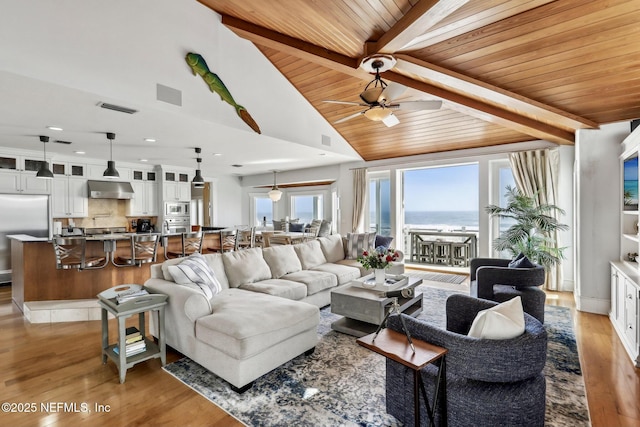 living area featuring vaulted ceiling with beams, ceiling fan, wood finished floors, wood ceiling, and visible vents