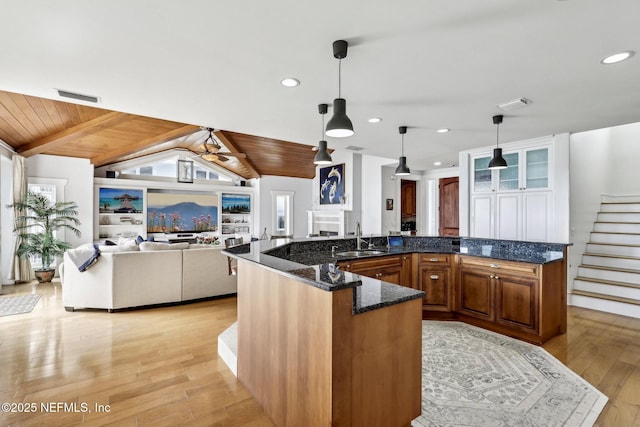 kitchen with vaulted ceiling with beams, wooden ceiling, light wood-style flooring, a sink, and visible vents