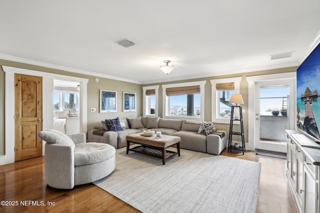 living room with a healthy amount of sunlight, visible vents, and light wood finished floors