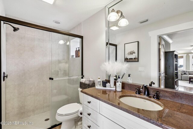 full bath featuring toilet, vanity, a shower stall, and visible vents