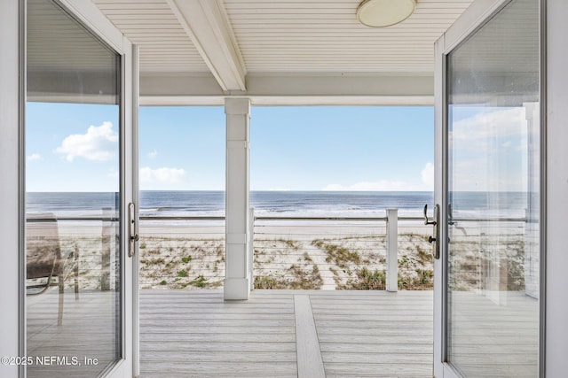 wooden deck with a water view and a view of the beach