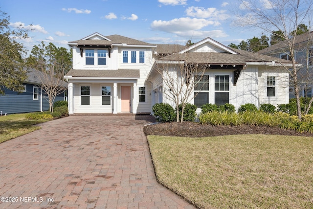 21 Mollusk Rd, Saint Johns, FL 32259 - view of front of home with decorative driveway, roof with shingles, covered porch, and a front yard