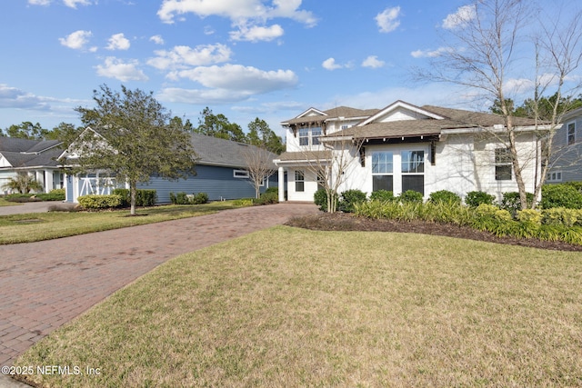 view of front of property featuring a front lawn and decorative driveway