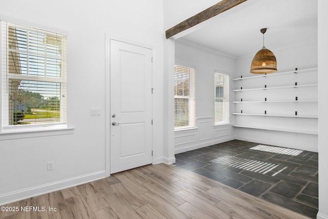 entryway featuring crown molding, baseboards, and wood finished floors