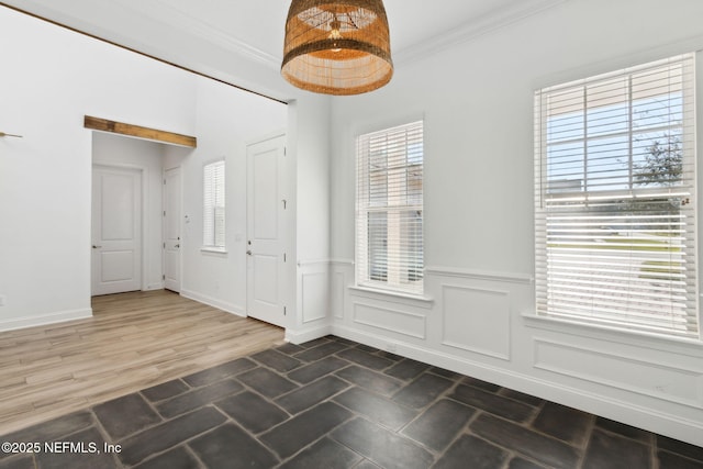 foyer with a wainscoted wall, a decorative wall, wood finished floors, and crown molding