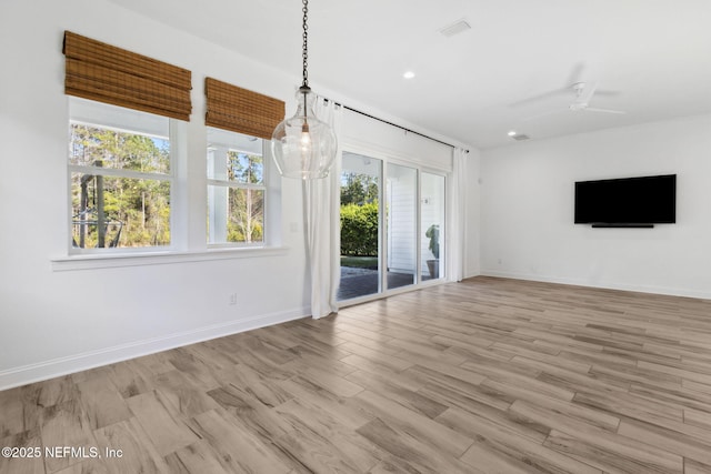 unfurnished living room featuring wood finished floors, visible vents, and baseboards