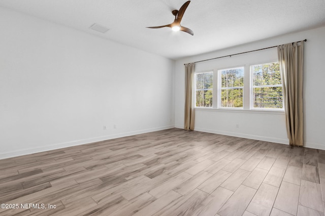 unfurnished room with light wood-style floors, ceiling fan, and baseboards