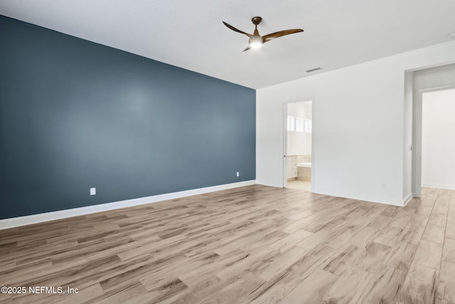 spare room with baseboards, visible vents, light wood-style flooring, and a ceiling fan