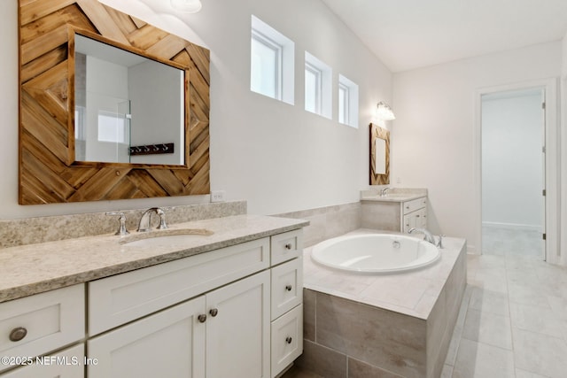 full bath with a garden tub, two vanities, a sink, and tile patterned flooring