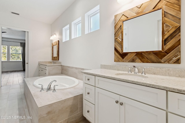 full bath with a garden tub, two vanities, visible vents, a sink, and tile patterned floors