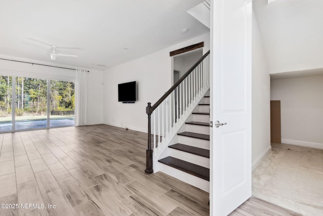 interior space with ceiling fan, stairs, baseboards, and wood finished floors