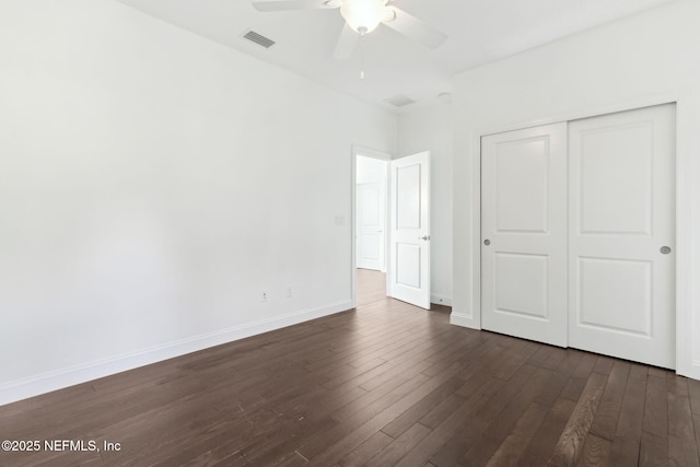 unfurnished bedroom with ceiling fan, visible vents, baseboards, a closet, and dark wood-style floors