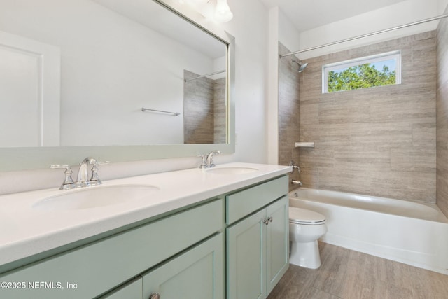 bathroom featuring toilet, double vanity, bathtub / shower combination, and a sink