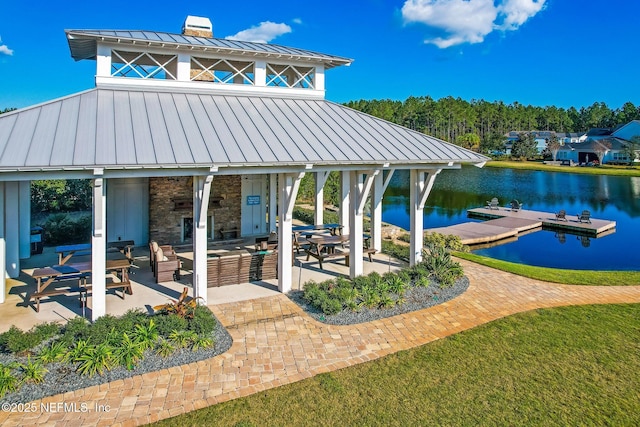 view of property's community with a patio, a water view, and a floating dock