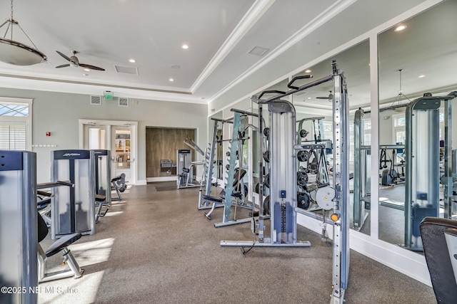 gym featuring a tray ceiling, visible vents, ceiling fan, and crown molding