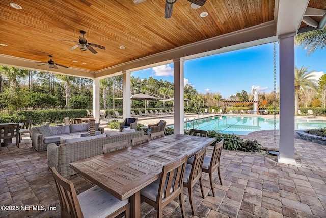 view of patio with a community pool and outdoor dining area