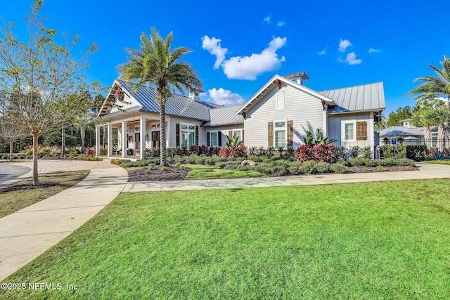 view of front of home with metal roof, a front lawn, and a standing seam roof