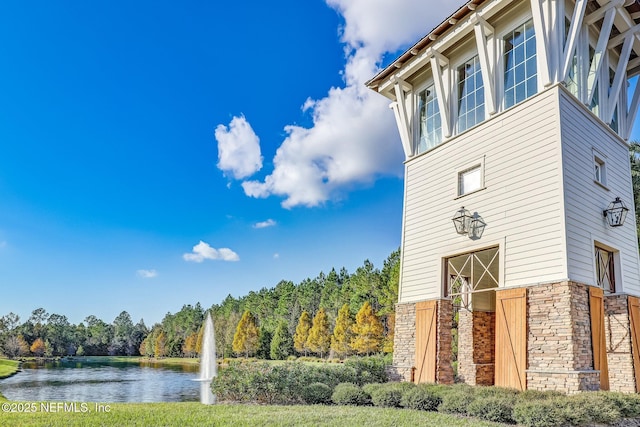 exterior space with stone siding and a water view