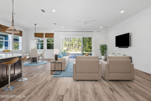 living room featuring light wood-style flooring, a wealth of natural light, and recessed lighting