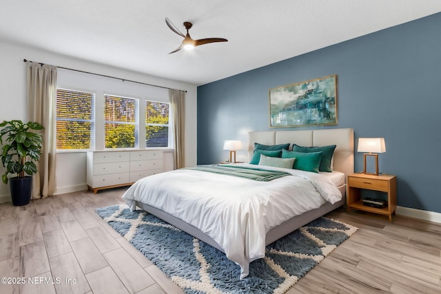 bedroom featuring a ceiling fan, baseboards, and wood finished floors