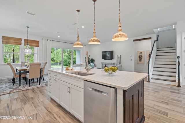 21 Mollusk Rd, Saint Johns, FL 32259 - kitchen with an island with sink, white cabinetry, a sink, dishwasher, and decorative light fixtures