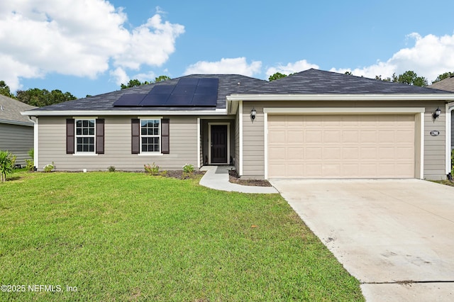 ranch-style house featuring a garage, roof mounted solar panels, a front lawn, and concrete driveway