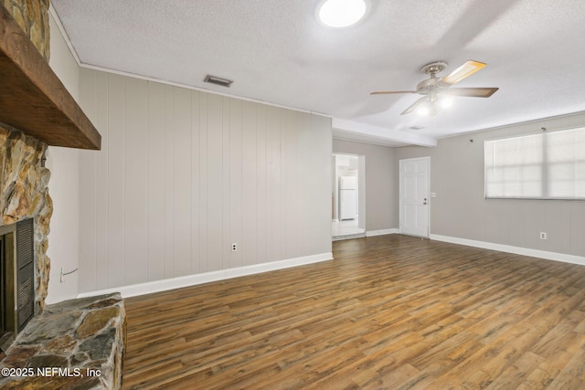 unfurnished living room featuring hardwood / wood-style flooring, ceiling fan, a textured ceiling, and a fireplace