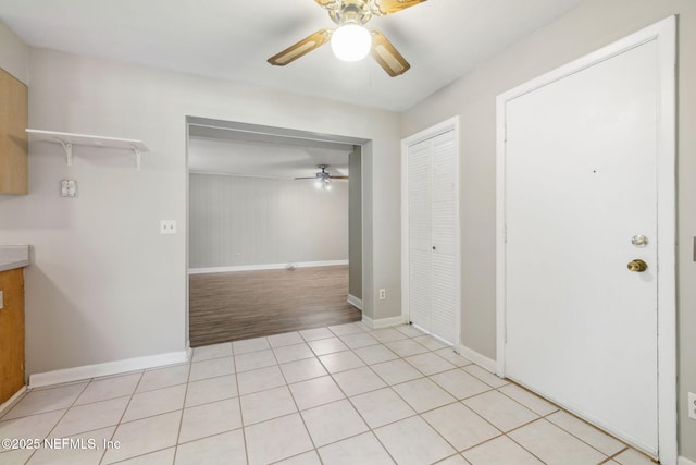 interior space with light tile patterned floors and ceiling fan