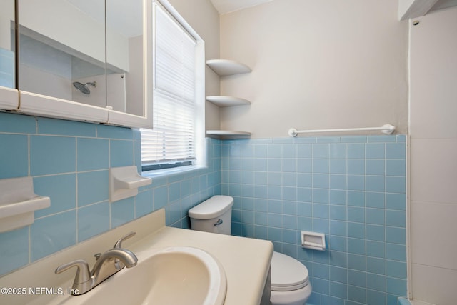 bathroom featuring vanity, tile walls, and toilet