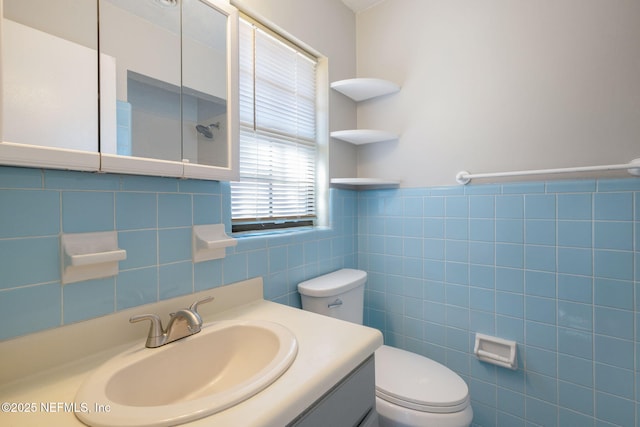 bathroom featuring vanity, toilet, and tile walls