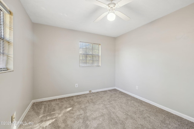 carpeted spare room featuring ceiling fan