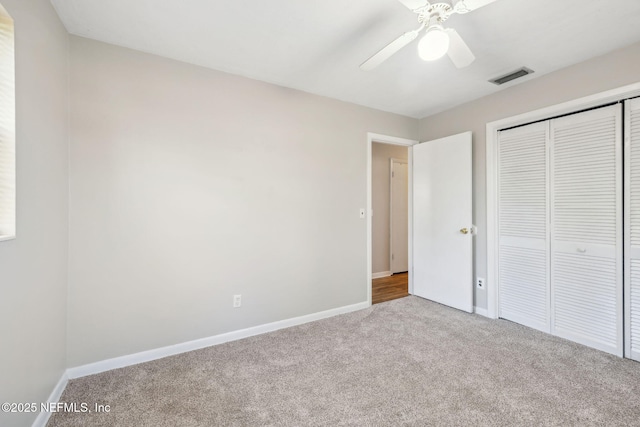 unfurnished bedroom featuring light colored carpet, a closet, and ceiling fan