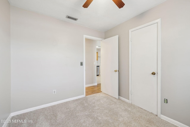 unfurnished bedroom with light colored carpet and ceiling fan