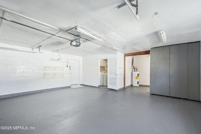 garage featuring a garage door opener, washer / dryer, and electric water heater