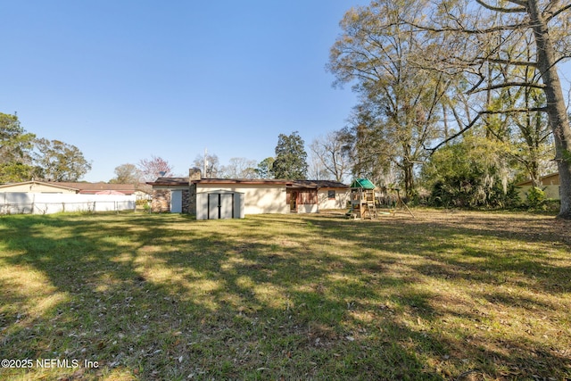 view of yard featuring a playground and a storage unit