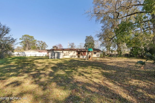 view of yard with a storage shed and a playground