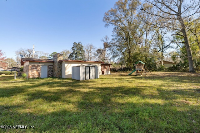 view of yard with a storage shed and a playground