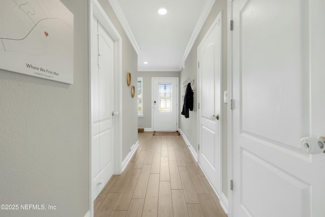 doorway with ornamental molding and light wood-type flooring