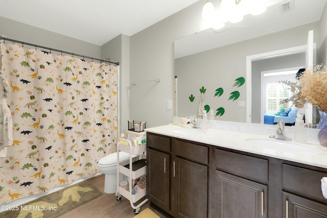 bathroom with wood-type flooring, vanity, and toilet