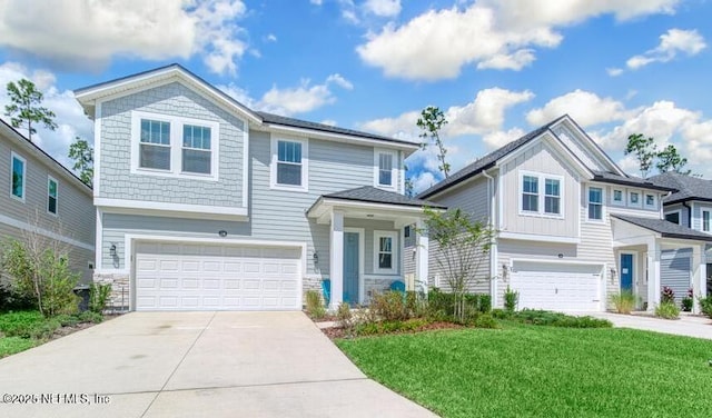 view of front of house with an attached garage, driveway, and a front lawn