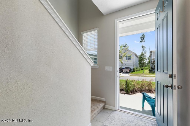 doorway to outside with light tile patterned floors