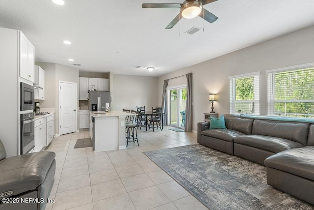 living room featuring light tile patterned flooring and ceiling fan