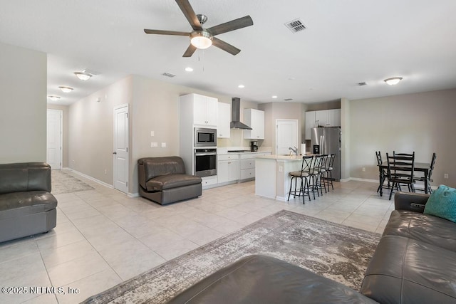 living room with light tile patterned floors, sink, and ceiling fan