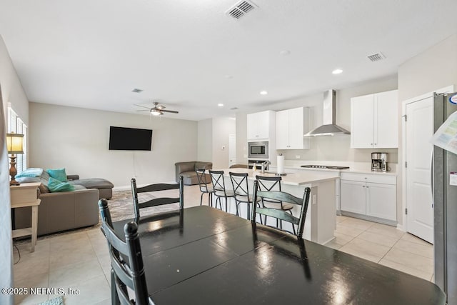 tiled dining space with ceiling fan and sink