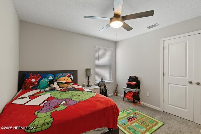 carpeted bedroom with ceiling fan and a textured ceiling