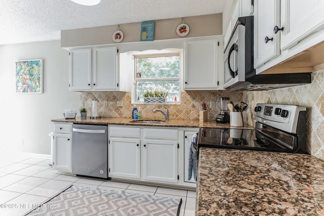 1045 17th St N, Jacksonville Beach, FL 32250 - kitchen with stainless steel appliances, white cabinetry, a sink, and dark stone countertops