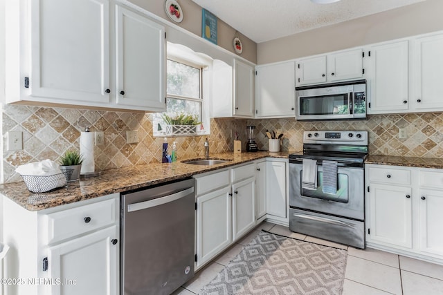 1045 17th St N, Jacksonville Beach, FL 32250 - kitchen featuring appliances with stainless steel finishes, white cabinets, and dark stone countertops