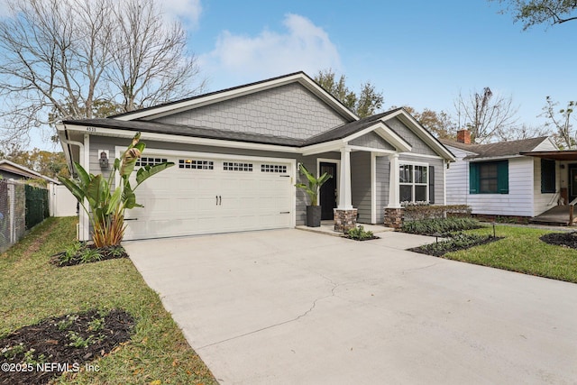 craftsman house featuring a garage, concrete driveway, fence, and a front lawn